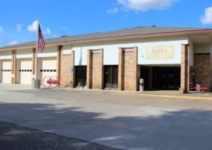front of Basile Town Hall building with Flagin front