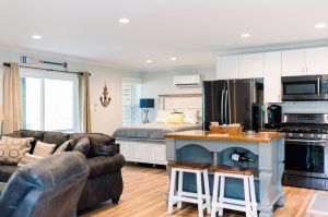inside view of studio apartment with a bed in the far background, kithen, and living room furniture in the foreground