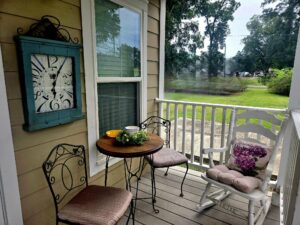 Quaint, country front porch with bistro table and clock
