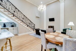 elegant dining/living area with chandelier and staircase