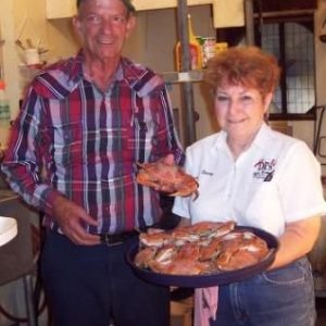 Cajun couple holding a platter of food.