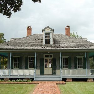 blue Acadian style house with large front porch, one dormer in he center, and two fireplaces, one on each side of the house