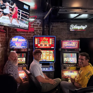 Three men sitting at video poker machines
