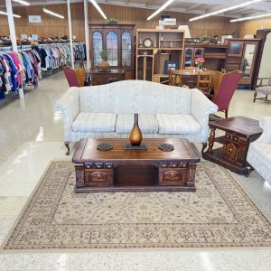 inside of thrift store with furniture in the center and clothes off to the side
